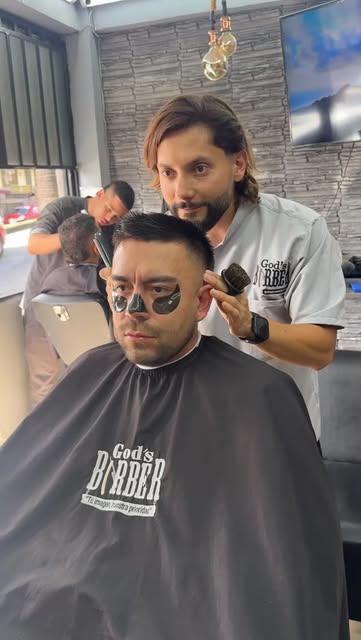 Cliente con mascarilla negra mientras le hacen el corte
