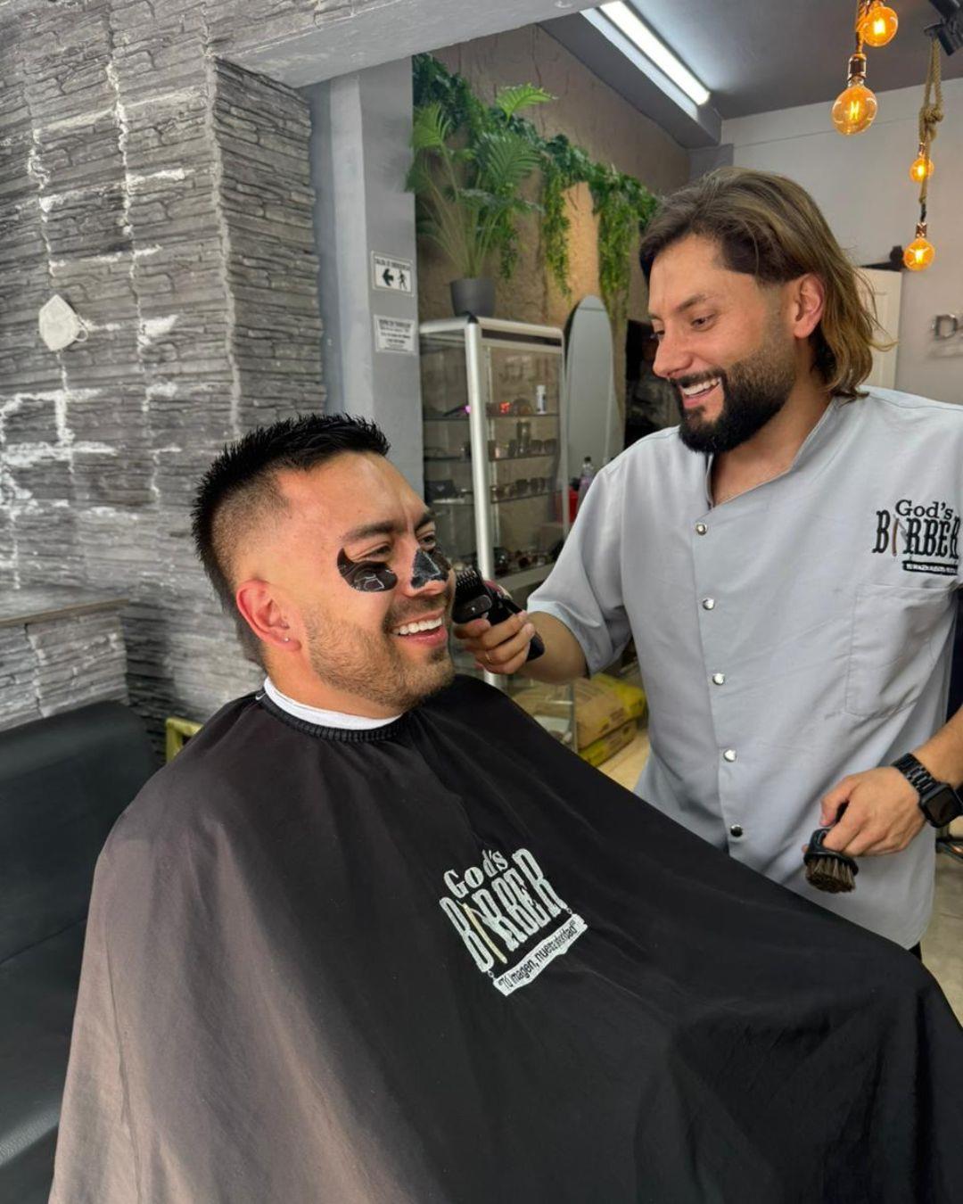 Cliente sonriendo con la mascarilla puesta mientras le arreglan la barba